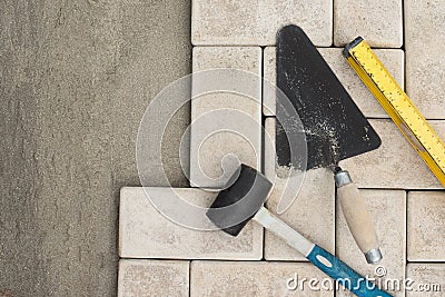 The master lays paving stones in layers. Garden brick pathway paving. Laying concrete paving slabs in house courtyard on sand Stock Photo