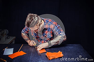 Master of leathercraft carrying out one of stages of production Stock Photo