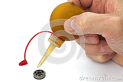 Master lubricates the old bearing of an using a oiler, isolated Stock Photo