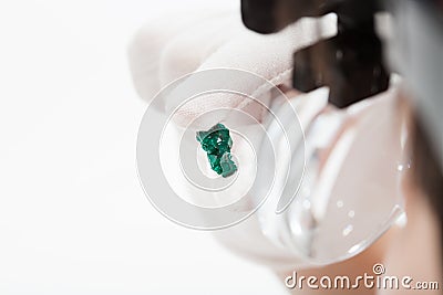 Master in magnifying glasses inspects dioptase Stock Photo