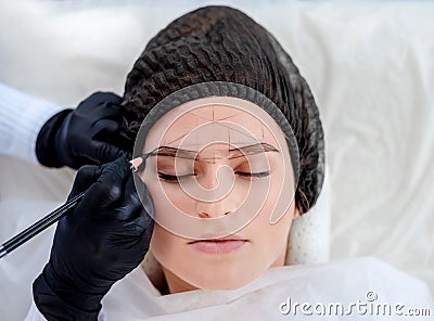 Master making eyebrows permanent makeup Stock Photo