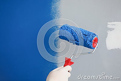 Master painter painting wall with roller blue closeup Stock Photo