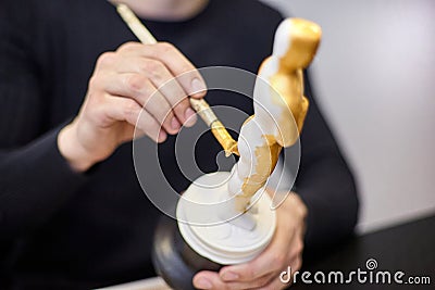 The master paints a replica of the Oscar figurine in yellow Editorial Stock Photo