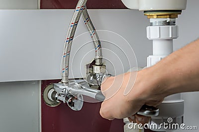 Master plumber repairs water faucets Stock Photo