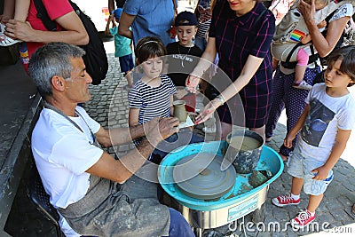 Master potter teaches children Editorial Stock Photo
