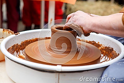 The master of pottery makes dishes from brown clay. Folk art Stock Photo