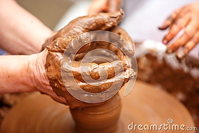 The master of pottery makes dishes from brown clay. Folk art Stock Photo