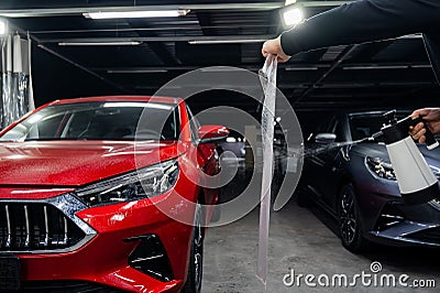 The master prepares the vinyl film before applying it to the car. Stock Photo