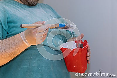 Red plastic paint pail used for holding paint and brush Stock Photo