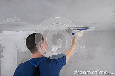 The master puts a finishing putty on the ceiling Stock Photo