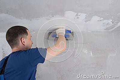 Master of repair of concrete walls, zashpaklevyvaem the junction of wall ceiling Stock Photo