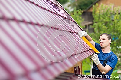 Master on repair of roofs makes measurements tool Stock Photo