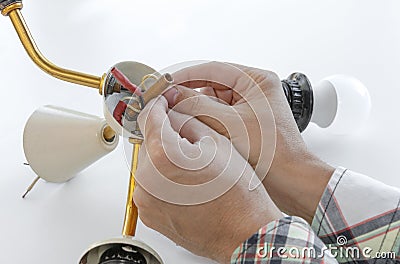 master repairs a disassembled electric lamp, close-up repair of a chandelier Stock Photo