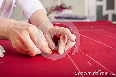 The master seamstress rocks two parts of the fabric with pins Stock Photo