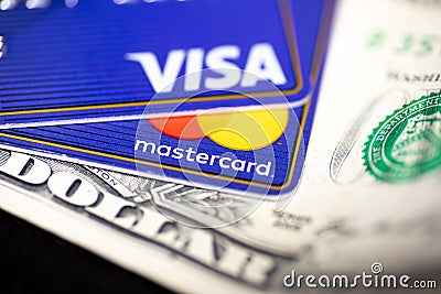 Mastercard and Visa card on a dollar bill Editorial Stock Photo