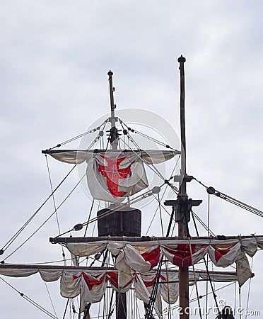the masts sails and rigging of the santa maria a historic sailing ship in funchal harbour with white sails with red crosses Stock Photo