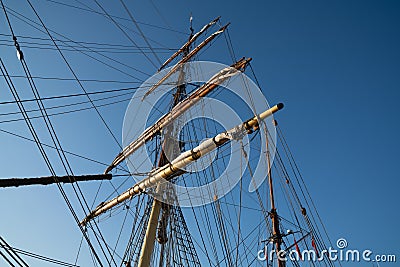 Masts, spars and rigging from low point of view against blue sky Stock Photo