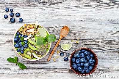 Matcha green tea breakfast superfoods smoothies bowl topped with chia, flax and pumpkin seeds, bee pollen, granola, coconut flakes Stock Photo