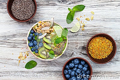 Matcha green tea breakfast superfoods smoothies bowl topped with chia, flax and pumpkin seeds, bee pollen, granola, coconut flakes Stock Photo