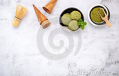 Matcha green tea ice cream with waffle cone and mint leaves setup on white stone background . Summer and Sweet menu concept Stock Photo