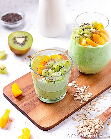 Matcha overnight oatmeal and fruits in glass, rich in protein breakfast or snack Stock Photo