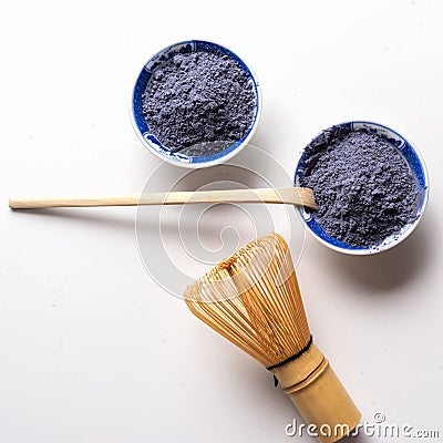 Matcha tea blue powder , whisk and wooden spoon isolated on white background Stock Photo