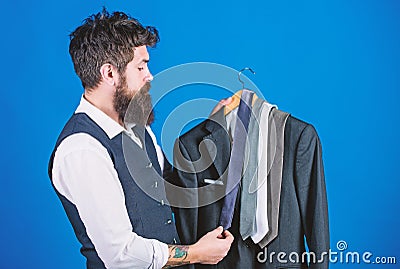 Matching necktie with outfit. Man bearded hipster hold neckties and formal suit. Guy choosing necktie. Perfect necktie Stock Photo