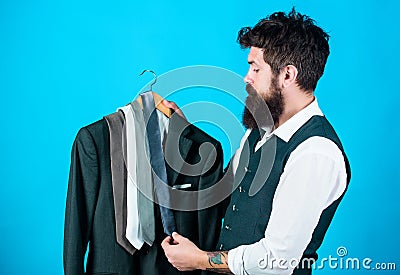 Matching necktie with outfit. Man bearded hipster hold neckties and formal suit. Guy choosing necktie. Perfect necktie Stock Photo