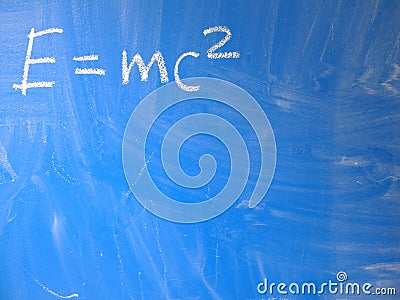 Mathematical formula e=mc2 squared written on a blue, relatively dirty chalkboard by chalk. Located in the upper left corner of Stock Photo