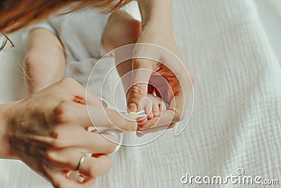 Parent hand holding scissors trimming child toenail Stock Photo