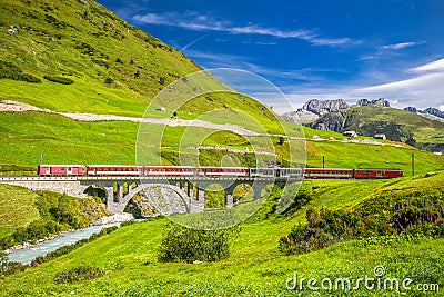 The Matterhorn - Gotthard - Bahn train on the viaduct bridge near Andermatt in Swiss Alps Stock Photo