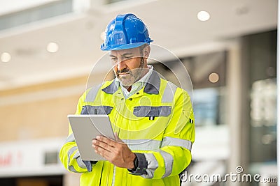 Mature architect using digital tablet at construcion site Stock Photo