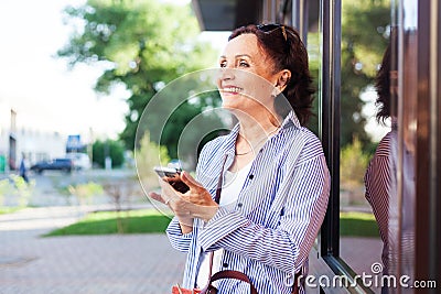 Mature attractive stylish woman retired using mobile phone app Stock Photo