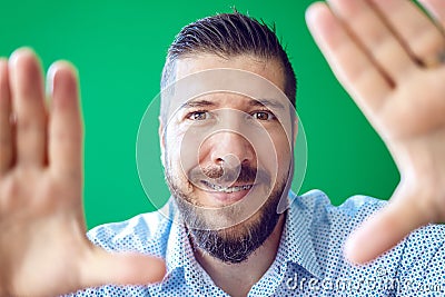 Mature bearded man with braces having fun making a frame with hands Stock Photo