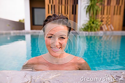 Mature beautiful Scandinavian tourist woman in swimming pool Stock Photo