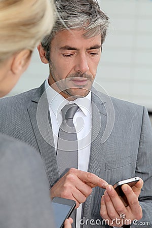 Mature business people exchanging phone numbers Stock Photo