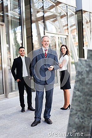 Mature businessman in front of a group of business people outdoor Stock Photo