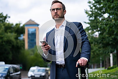 Mature Businessman Ordering Taxi Using Mobile Phone App Stock Photo