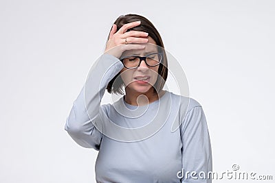 Mature caucasian woman has a terrible headache, isolated on white wall. Stock Photo