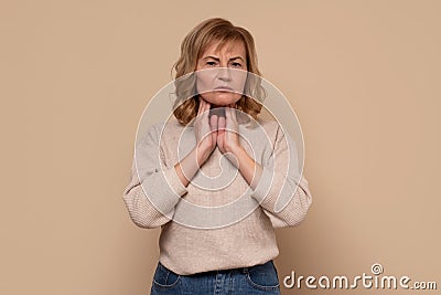 Mature caucasian woman with sore throat doing palpation. Stock Photo