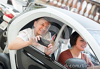 Mature couple driving twizy electric . Stock Photo