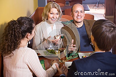 Mature couple with friends having dinner and wine at restaurant Stock Photo