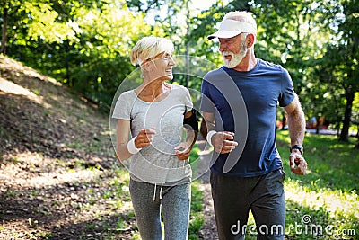 Mature couple jogging and running outdoors in city Stock Photo