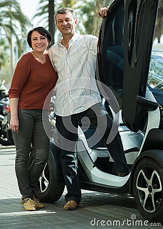 Mature couple near twizy electric Stock Photo