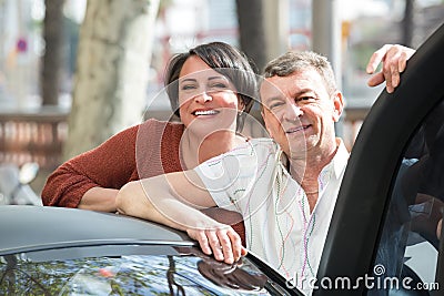 Mature couple near twizy electric Stock Photo