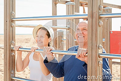 Mature couple together training on pull-up bar Stock Photo