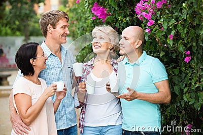 Mature couples walking and drinking coffee on holiday Stock Photo