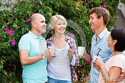 Mature couples walking and drinking coffee on holiday Stock Photo