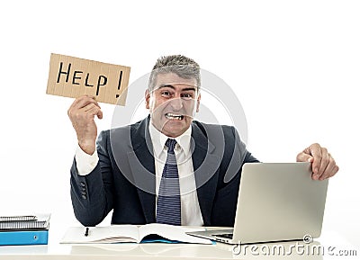 Mature desperate businessman suffering stress working at computer desk holding sign asking for help looking stressed overworked Stock Photo