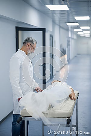 A mature doctor carrying the gurney with a patient Stock Photo